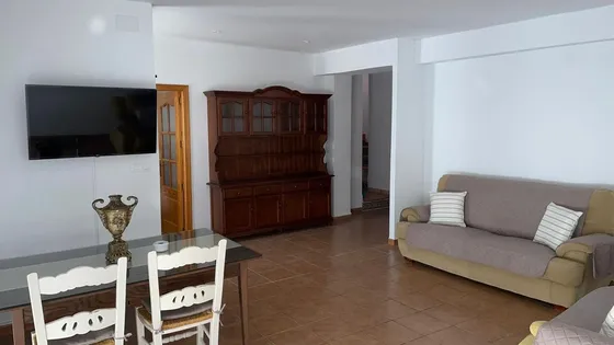 Salón amplio para grupos, con sofá y zona de relax en casa rural.