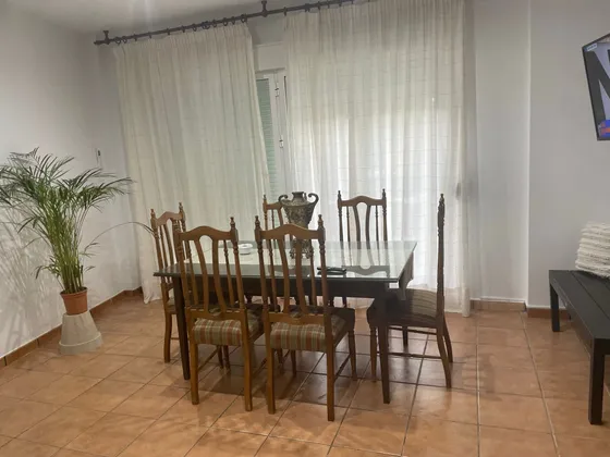 Salón comedor con mesa grande para comidas en grupo.